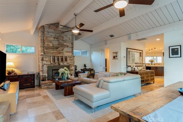 living room with vaulted ceiling with beams and a fireplace