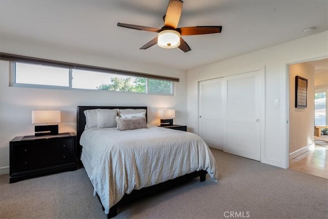 carpeted bedroom featuring ceiling fan and a closet