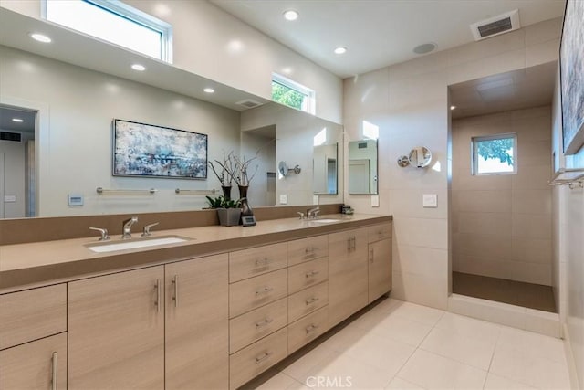 bathroom with vanity, tile patterned flooring, and a tile shower