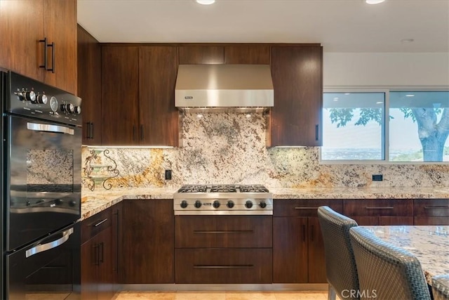 kitchen with stainless steel gas stovetop, backsplash, black double oven, exhaust hood, and light stone countertops