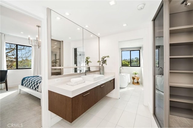 ensuite bathroom featuring ensuite bathroom, an inviting chandelier, a freestanding bath, vanity, and recessed lighting