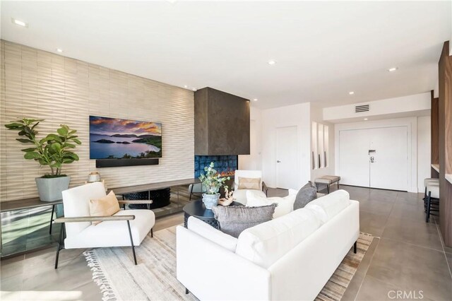 living room featuring a fireplace and concrete flooring