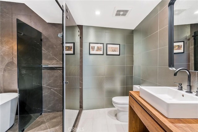 bathroom featuring toilet, a stall shower, visible vents, and tile walls