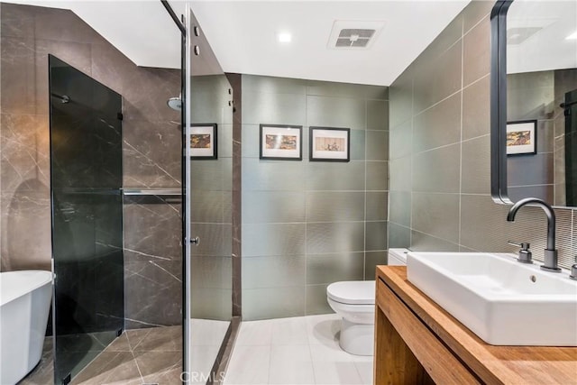 bathroom featuring tile walls, visible vents, and toilet