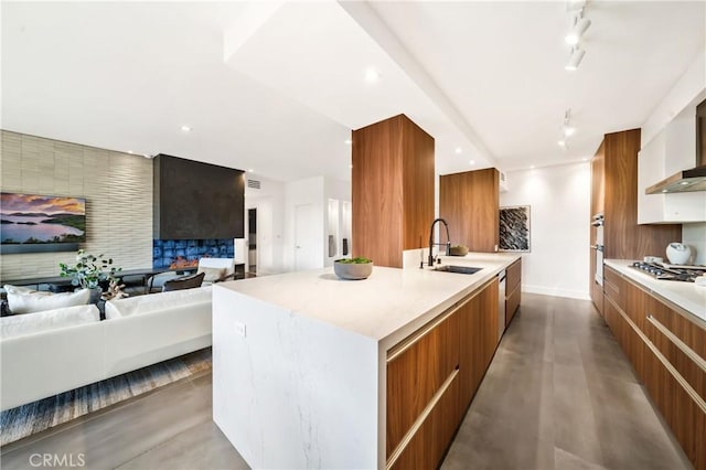 1223 Roxbury Dr Unit 202, Los Angeles, CA 90035 - kitchen featuring modern cabinets, open floor plan, brown cabinets, a large island with sink, and stainless steel gas cooktop