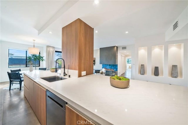 kitchen with visible vents, brown cabinetry, a sink, modern cabinets, and dishwasher