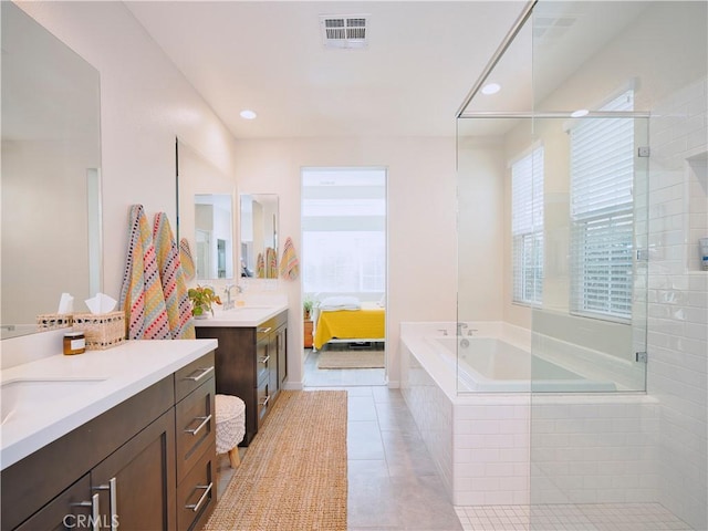 bathroom featuring a healthy amount of sunlight, tile patterned floors, shower with separate bathtub, and vanity