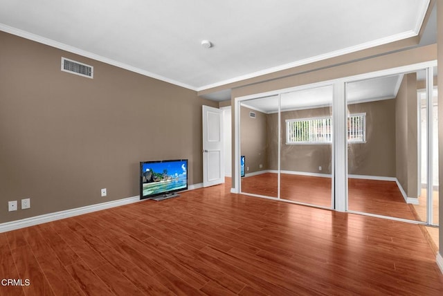 unfurnished bedroom with hardwood / wood-style flooring and ornamental molding