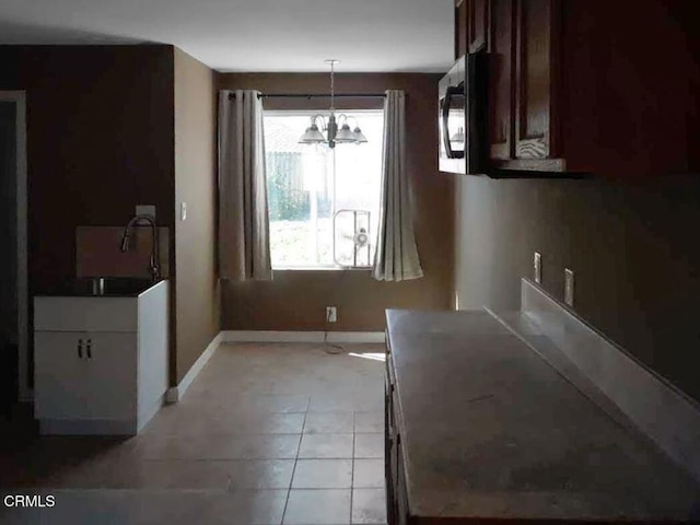 unfurnished dining area with sink and a notable chandelier