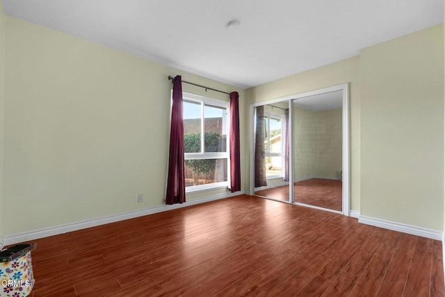 unfurnished bedroom with hardwood / wood-style floors and a closet