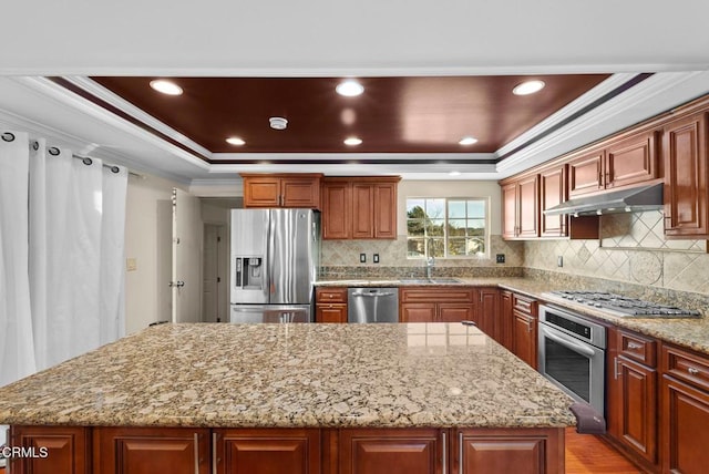 kitchen featuring sink, ornamental molding, a center island, stainless steel appliances, and light stone countertops