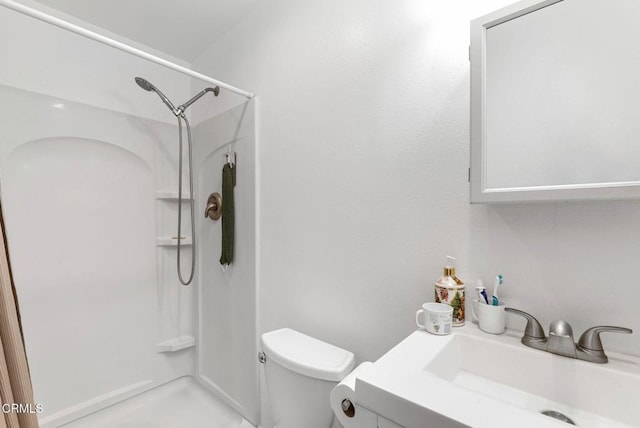 bathroom with vanity, toilet, and a shower