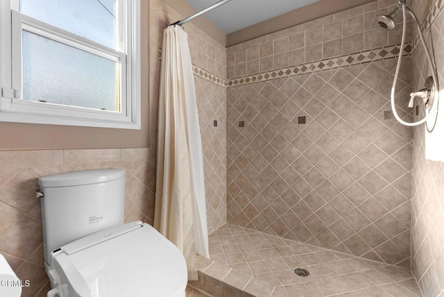 bathroom featuring curtained shower, tile walls, and toilet