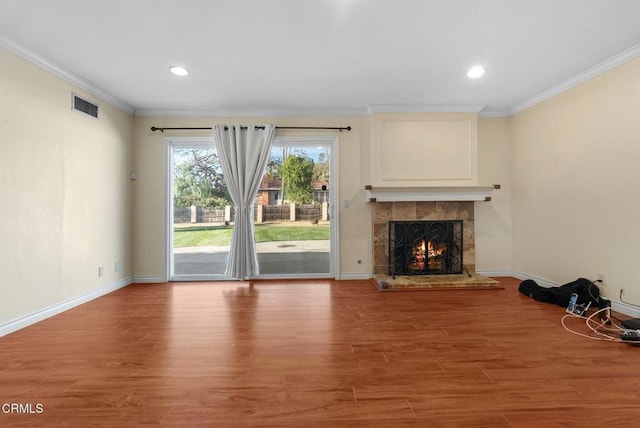 unfurnished living room featuring ornamental molding, hardwood / wood-style floors, and a fireplace