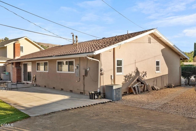 back of property with a patio and central AC