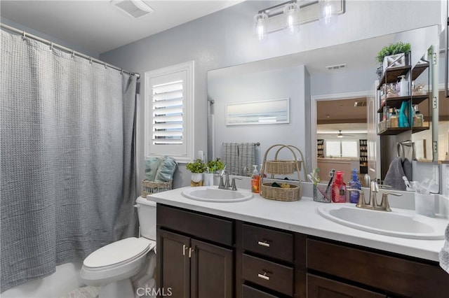 full bathroom with vanity, shower / bath combo with shower curtain, and toilet