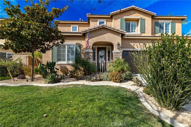 mediterranean / spanish-style home featuring a garage and a front yard