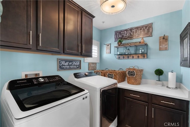 clothes washing area with cabinets and washer and clothes dryer