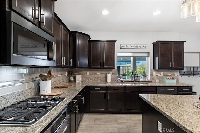 kitchen featuring tasteful backsplash, appliances with stainless steel finishes, sink, and dark brown cabinets