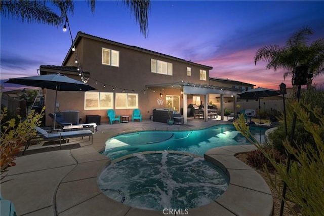 back house at dusk with a swimming pool with hot tub, a patio, and central AC unit