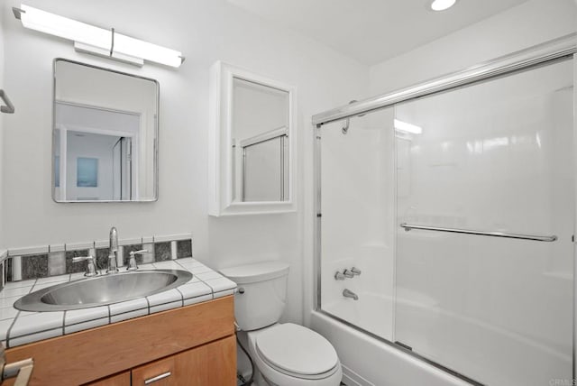 full bathroom featuring enclosed tub / shower combo, vanity, and toilet