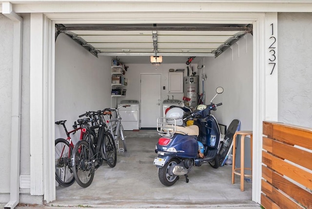 garage with a garage door opener, separate washer and dryer, and gas water heater