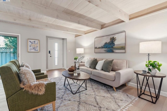 living room with plenty of natural light, beam ceiling, and light wood-type flooring