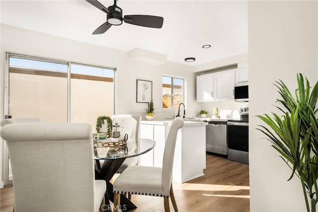 dining space with light wood-style flooring and ceiling fan