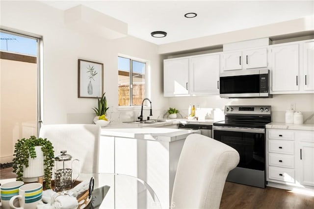 kitchen featuring white cabinetry, light countertops, appliances with stainless steel finishes, and a sink