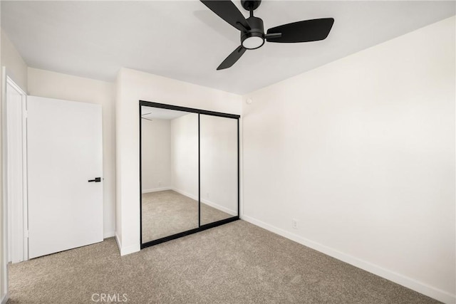 unfurnished bedroom featuring a closet, baseboards, and carpet