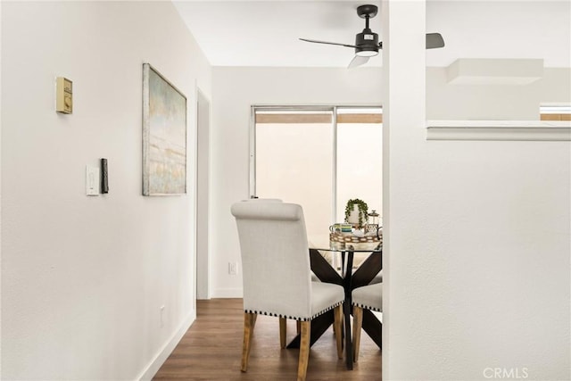 dining area featuring baseboards, a ceiling fan, and wood finished floors