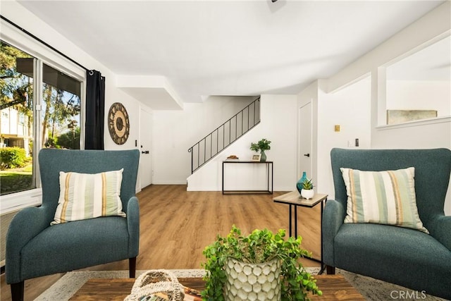 living area featuring stairway and wood finished floors