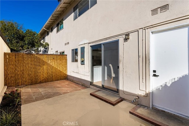 view of patio with visible vents and fence