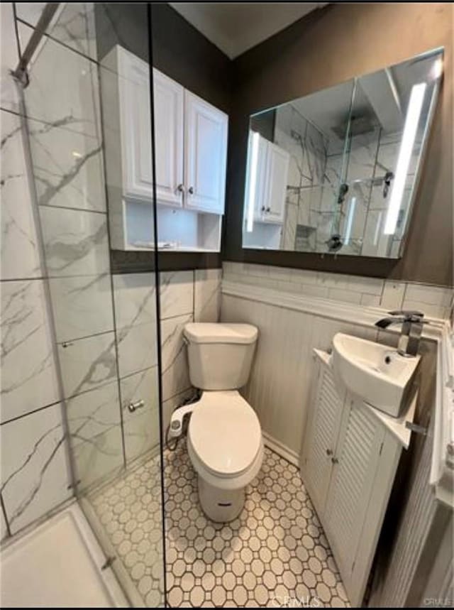 bathroom featuring vanity, toilet, and a shower with shower door