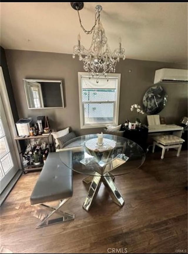 dining space with an inviting chandelier, a wall mounted air conditioner, and light hardwood / wood-style floors