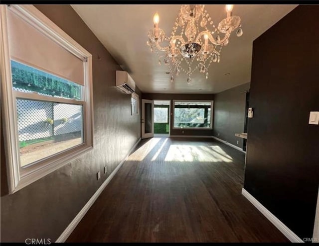 corridor featuring an inviting chandelier, hardwood / wood-style floors, and an AC wall unit