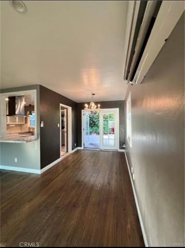 unfurnished living room featuring dark hardwood / wood-style floors and a notable chandelier