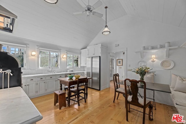 kitchen with white cabinetry, lofted ceiling, built in fridge, and light wood-type flooring