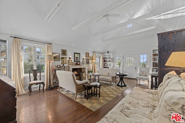 living room featuring beam ceiling, dark wood-type flooring, and high vaulted ceiling