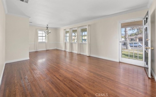 empty room featuring crown molding, a notable chandelier, and dark hardwood / wood-style flooring