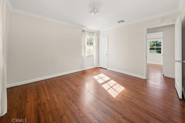 empty room featuring ornamental molding and dark hardwood / wood-style floors