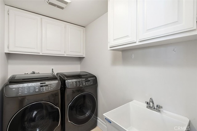 laundry room with sink, washer and clothes dryer, and cabinets