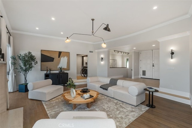 living room featuring crown molding, track lighting, and hardwood / wood-style flooring