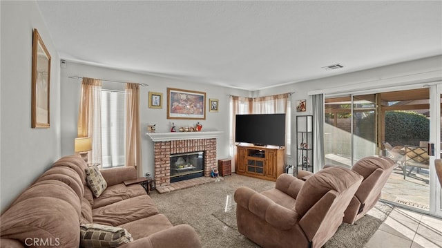 living room featuring a healthy amount of sunlight, light colored carpet, a textured ceiling, and a fireplace