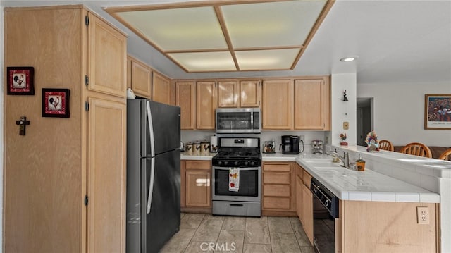 kitchen with stainless steel appliances, sink, light brown cabinetry, and kitchen peninsula