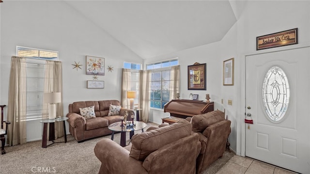 living room with a healthy amount of sunlight, light tile patterned floors, and high vaulted ceiling