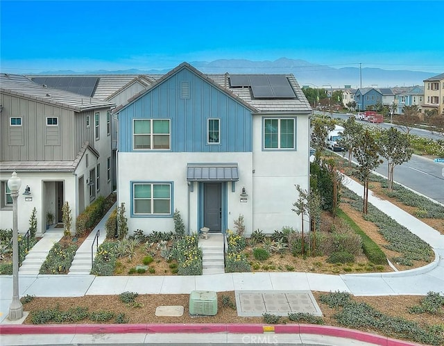 view of front of house with a mountain view and solar panels