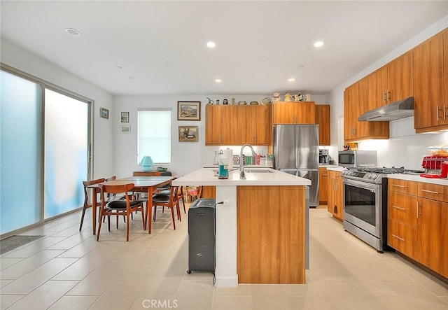 kitchen featuring an island with sink, appliances with stainless steel finishes, sink, and light tile patterned floors