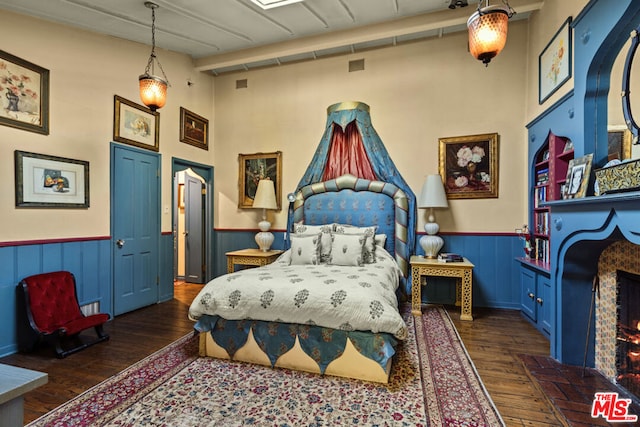 bedroom featuring dark hardwood / wood-style flooring and a tile fireplace