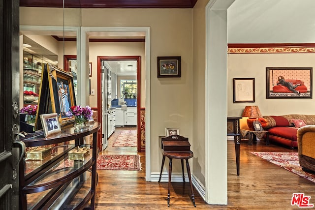 hall featuring ornamental molding and dark hardwood / wood-style floors